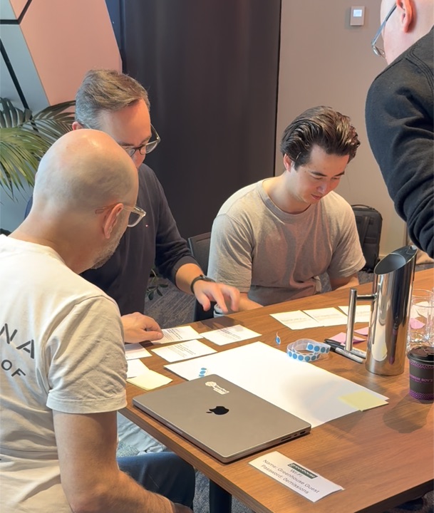 A small group looking through discussion cards around a table.